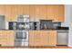 Modern kitchen featuring stainless steel appliances, dark backsplash, and ample wood cabinetry at 777 N Ashley Dr # 1915, Tampa, FL 33602