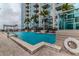 Stunning pool area with lounge chairs and a view of the city skyline beyond palm trees at 777 N Ashley Dr # 1915, Tampa, FL 33602