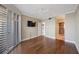 Bedroom featuring a ceiling fan, hardwood floors, TV, and access to bathroom at 7892 Sailboat Key S Blvd # 107, South Pasadena, FL 33707