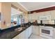 Well-lit kitchen with stainless sink, white cabinets and granite counter tops at 7892 Sailboat Key S Blvd # 107, South Pasadena, FL 33707