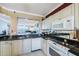 Bright kitchen with white appliances, a mirrored backsplash and granite countertops at 7892 Sailboat Key S Blvd # 107, South Pasadena, FL 33707
