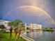 Enjoy the view of the building with tropical palms, landscaping and a vivid rainbow at 7892 Sailboat Key S Blvd # 107, South Pasadena, FL 33707