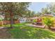A spacious backyard with a deck featuring patio furniture, set against a backdrop of green grass and mature trees at 907 E Hamilton Ave, Tampa, FL 33604