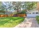 Backyard featuring green grass, a trampoline, a wooden playhouse, and a paved walkway at 907 E Hamilton Ave, Tampa, FL 33604