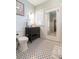 Bathroom with stylish black and white tile, vanity, toilet, and bright lighting at 907 E Hamilton Ave, Tampa, FL 33604