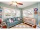 Bright bedroom features hardwood floors, multiple windows, comfortable sofa, and a crib at 907 E Hamilton Ave, Tampa, FL 33604