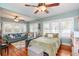 Bright bedroom features hardwood floors, multiple windows, sofa, a crib, and a bed at 907 E Hamilton Ave, Tampa, FL 33604