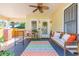 Inviting front porch with a ceiling fan, seating, and colorful rug creating a cozy outdoor living space at 907 E Hamilton Ave, Tampa, FL 33604