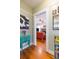 Hallway with hardwood floors leads to living room with an orange sofa and fireplace at 907 E Hamilton Ave, Tampa, FL 33604