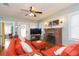 Living room featuring hardwood floors, fireplace, television, and comfortable seating at 907 E Hamilton Ave, Tampa, FL 33604