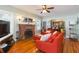 Cozy living room featuring hardwood floors, a brick fireplace, comfortable seating, and an open layout at 907 E Hamilton Ave, Tampa, FL 33604