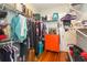 Efficient walk-in closet with organized shelving, clothing racks, and orange dresser for optimal storage at 907 E Hamilton Ave, Tampa, FL 33604