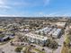 Wide aerial view displays the low-rise apartment building in a neighborhood with trees, streets, and city skyline in distance at 100 Waverly Way # 101, Clearwater, FL 33756