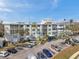 Low-rise apartment building with private terraces, surrounded by palm trees and ample parking on a clear day at 100 Waverly Way # 101, Clearwater, FL 33756