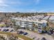Exterior view of a light blue apartment building with private balconies and parking, enhanced with palm trees at 100 Waverly Way # 101, Clearwater, FL 33756