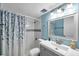 Stylishly updated bathroom featuring blue walls, shower, and modern vanity at 100 Waverly Way # 101, Clearwater, FL 33756