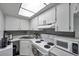 Bright kitchen featuring white cabinets, gray backsplash, and modern appliances at 100 Waverly Way # 101, Clearwater, FL 33756