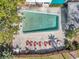 Aerial shot of a private pool with lounge seating and tables surrounded by greenery and a fence at 100 Waverly Way # 101, Clearwater, FL 33756