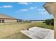 View of the home's backyard featuring a patio, lawn, and a scenic lake beyond the black fence at 10328 Celtic Ash Dr, Ruskin, FL 33573