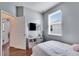Inviting bedroom with wood floors, bright window, and a wall mounted television at 10328 Celtic Ash Dr, Ruskin, FL 33573
