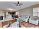 Open-concept living area with hardwood floors, a ceiling fan, and access to the dining area at 10328 Celtic Ash Dr, Ruskin, FL 33573