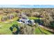 Aerial view of the blue home with solar panels and a large yard surrounded by mature trees at 10946 Gun Dog Way, Lithia, FL 33547