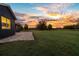 Paver patio and sprawling green lawn bathed in the warm glow of a colorful sunset at 10946 Gun Dog Way, Lithia, FL 33547