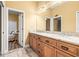 Bright bathroom featuring a double vanity with granite countertops and decorative mirror lighting at 10946 Gun Dog Way, Lithia, FL 33547