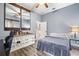 Comfortable bedroom boasts sliding barn door, laminate floors, accent dresser, and cool blue walls at 10946 Gun Dog Way, Lithia, FL 33547