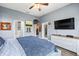 Comfortable bedroom with a ceiling fan, TV, and ample natural light from the windows at 10946 Gun Dog Way, Lithia, FL 33547