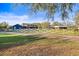 Beautiful blue farmhouse exterior with a lush green lawn and split rail fence on a sunny day at 10946 Gun Dog Way, Lithia, FL 33547