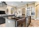 Gourmet kitchen island featuring a stainless steel farmhouse sink and dark granite countertops, perfect for cooking and entertaining at 10946 Gun Dog Way, Lithia, FL 33547