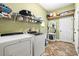 Well-equipped laundry room with washer, dryer, and storage shelves at 10946 Gun Dog Way, Lithia, FL 33547