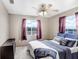 Bedroom with a ceiling fan, a large window with purple curtains and a dresser at 11050 Revell Rd, Duette, FL 34219