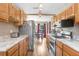 Galley kitchen featuring stainless steel appliances, stone countertops, wood floors, with view to a window and the dining area at 11050 Revell Rd, Duette, FL 34219