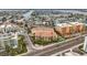 Aerial shot of a yellow condo complex next to a beautiful waterfront, pool, and a lively road at 11555 Gulf Blvd Blvd # 115, Treasure Island, FL 33706