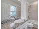 Bright bathroom featuring a granite countertop, stylish faucet, and tiled shower at 11555 Gulf Blvd Blvd # 115, Treasure Island, FL 33706