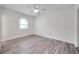 A spacious bedroom with hardwood floors, a ceiling fan, and a large window at 11555 Gulf Blvd Blvd # 115, Treasure Island, FL 33706