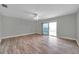 Bedroom featuring wood floors, ceiling fan, and sliding doors to balcony at 11555 Gulf Blvd Blvd # 115, Treasure Island, FL 33706