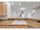 Bright kitchen features granite countertops, a double sink, and an open view to the living area at 11555 Gulf Blvd Blvd # 115, Treasure Island, FL 33706