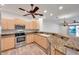 Open kitchen with stainless steel appliances and wood-style flooring, blending style and functionality at 11555 Gulf Blvd Blvd # 115, Treasure Island, FL 33706