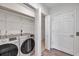 Modern laundry room with stainless steel washer and dryer and wire shelving at 11555 Gulf Blvd Blvd # 115, Treasure Island, FL 33706