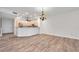 Living room view showcasing the hardwood floors, lighting, and a partial kitchen view at 11555 Gulf Blvd Blvd # 115, Treasure Island, FL 33706