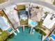 An aerial view showcases a waterfront property with a private dock and a cozy blue home at 14050 W Parsley Dr, Madeira Beach, FL 33708