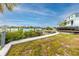 Scenic backyard featuring a waterfront view with a private dock and lush greenery at 14050 W Parsley Dr, Madeira Beach, FL 33708