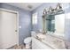 Updated bathroom with a granite-topped vanity and shower with blue tile surround at 14050 W Parsley Dr, Madeira Beach, FL 33708
