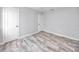 Bedroom with wood-look tile flooring, white walls, and two white doors at 14050 W Parsley Dr, Madeira Beach, FL 33708