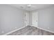 This bedroom features gray wood-look floors, two windows that provide ample natural light, and a modern ceiling fan at 14050 W Parsley Dr, Madeira Beach, FL 33708