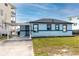 Charming single-story home featuring a carport, light blue exterior, and well-maintained lawn at 14050 W Parsley Dr, Madeira Beach, FL 33708