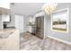 Open kitchen with stainless steel appliances, stone counters, and a modern lighting fixture at 14050 W Parsley Dr, Madeira Beach, FL 33708
